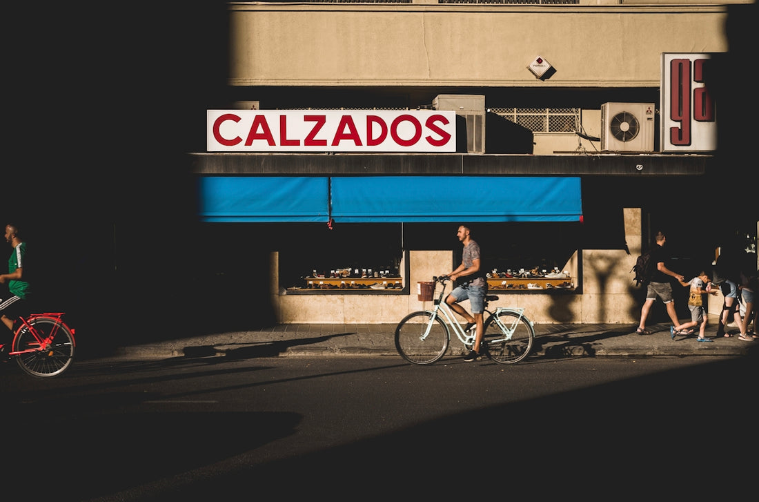 man riding bike near Calzados store
