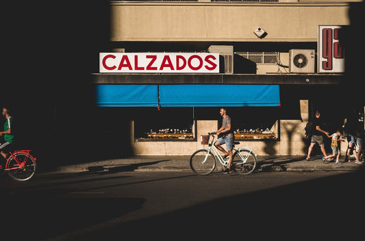 man riding bike near Calzados store