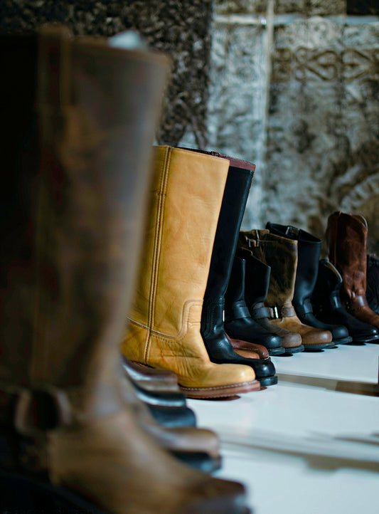 selective focus photography of boots beside wall