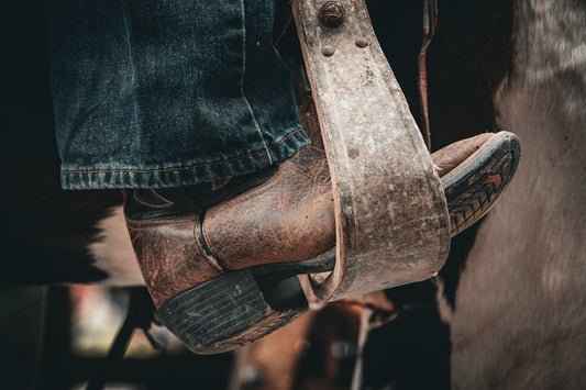 A pair of brown boots sitting on top of a person's legs